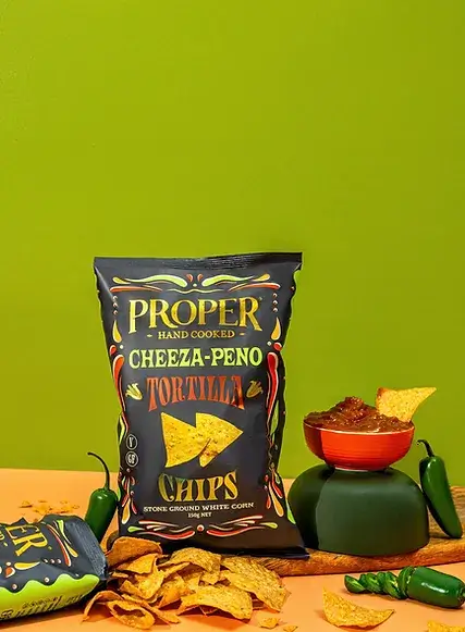 cheeza-peño tortilla chips lifestyle image jalapeño jalapeno salsa in a red bowl tortilla chips scattered