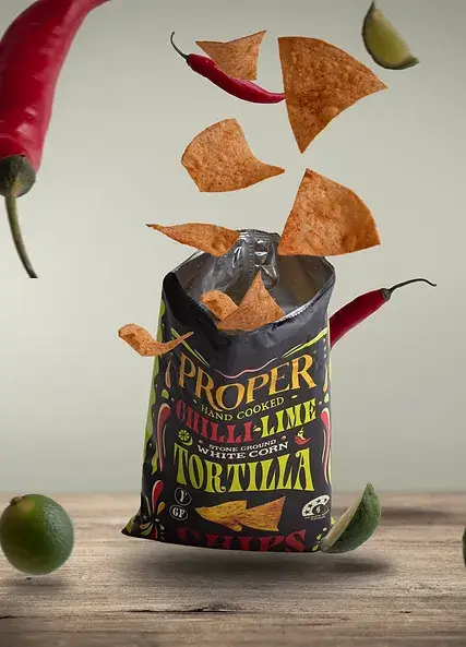 chilli-lime tortilla chips lifestyle image chilli-lime tortilla chips exploding out of the bag